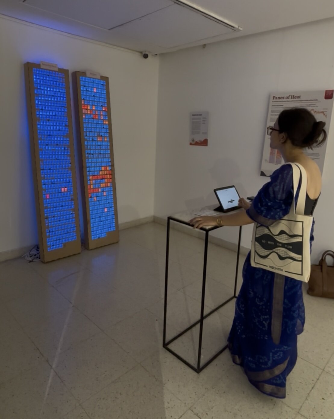 Visitor at the interactive station beside the illuminated Panes of Heat towers
