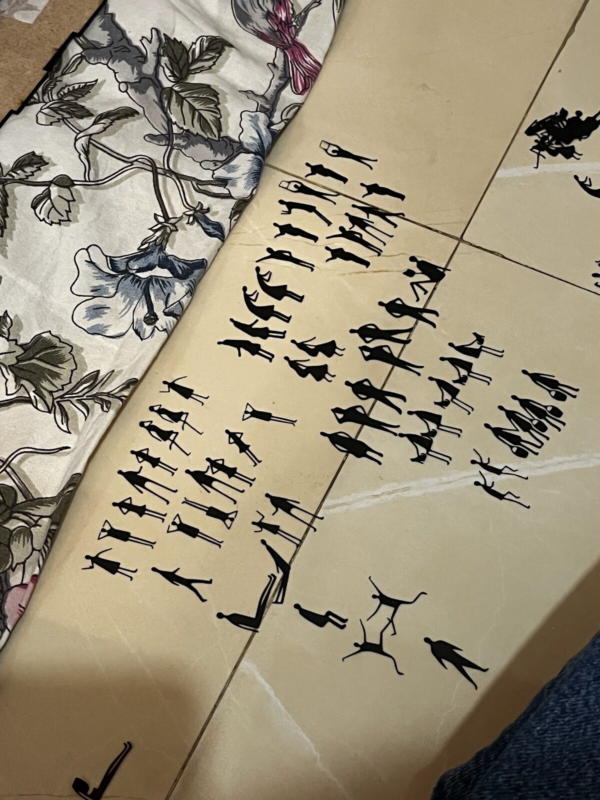 Sheets of cut stick-figure silhouettes ready to be placed on the towers
