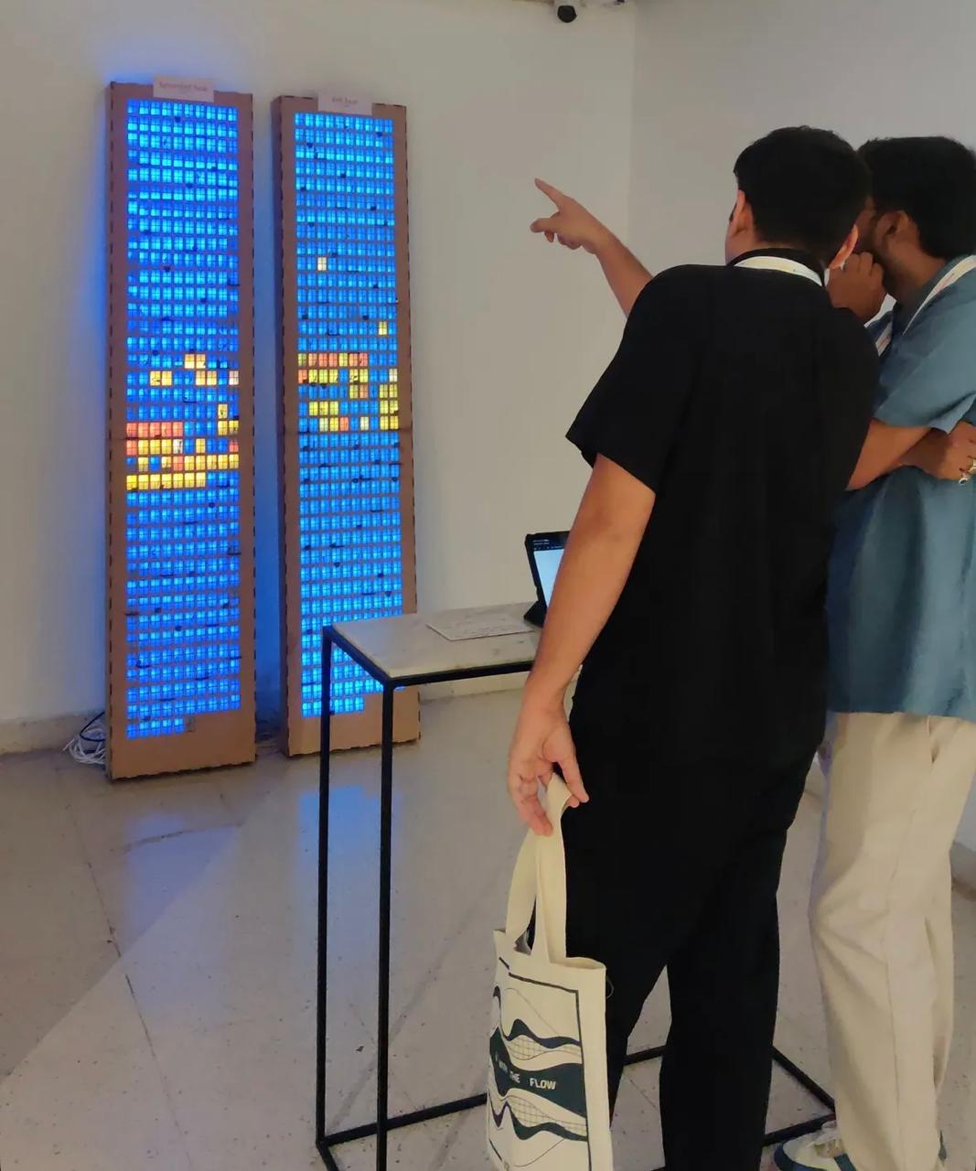 Visitors pointing at the illuminated towers during the exhibition